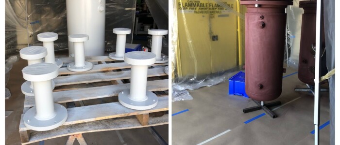 Before and After photo of two 6 foot tall red industrial equipment pieces before painting on the right and 1 tall and 7 small freshly painted white industrial equipment pieces on pallets in a paint booth set up.
